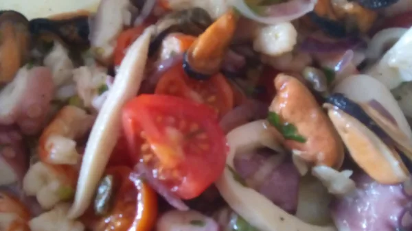 Insalata di mare con cozze, gamberi, calamari, patate, capperi e pomodorini