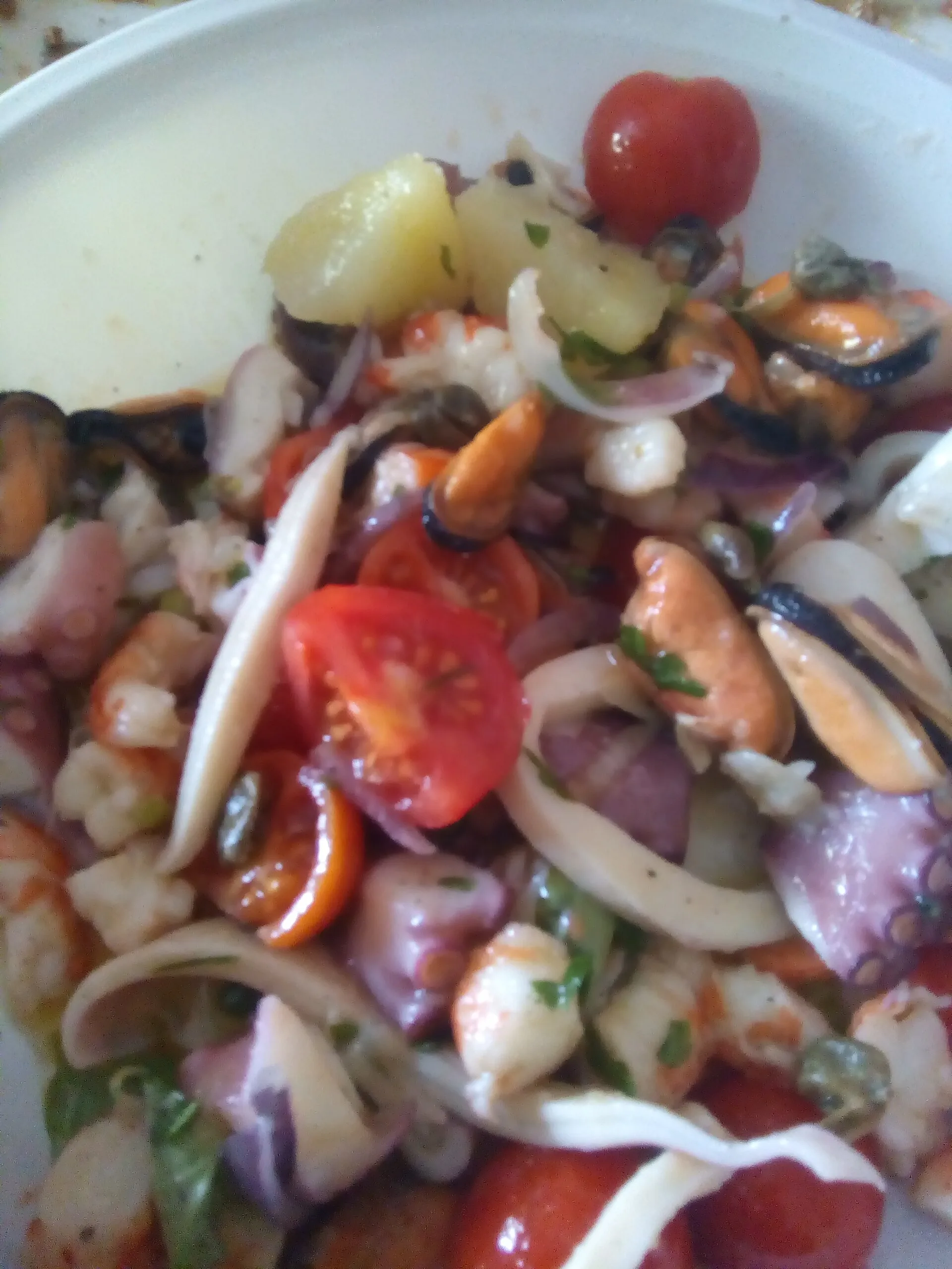 Insalata di mare con cozze, gamberi, calamari, patate, capperi e pomodorini