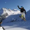 Snowboarder in salto su neve fresca nel gruppo dell'Adamello