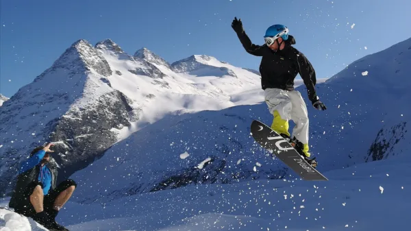 Snowboarder in salto su neve fresca nel gruppo dell'Adamello
