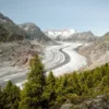 Previsioni montagna: ghiacciaio tra le montagne delle Alpi con boschi di conifere