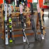 Come scegliere gli sci da pista: sci alpini appoggiati a una rastrelliera in una stazione sciistica