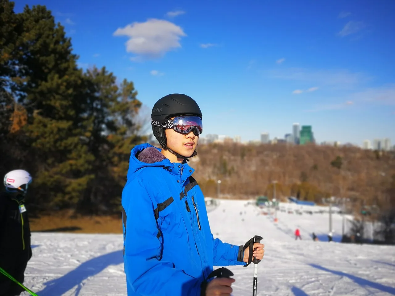 Sciatore con casco, maschera e giacca blu